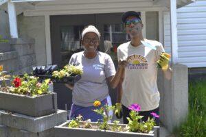 Two Camp Loyaltown staff members getting ready for opening day by planting flowers.